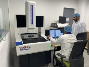 Two Technicians in a lab testing materials using a video measuring system