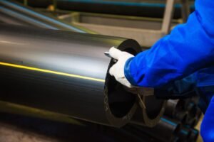 Worker checking pipes with pipe testing equipment in a factory